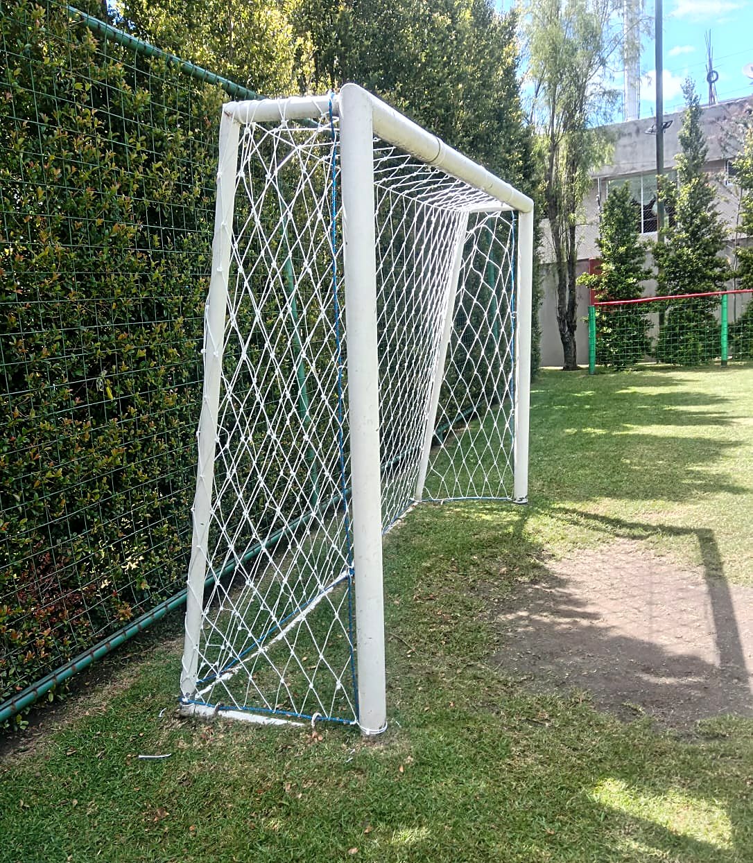 Red blanca en arco de cancha de césped